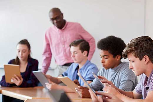 students in class with teacher observing